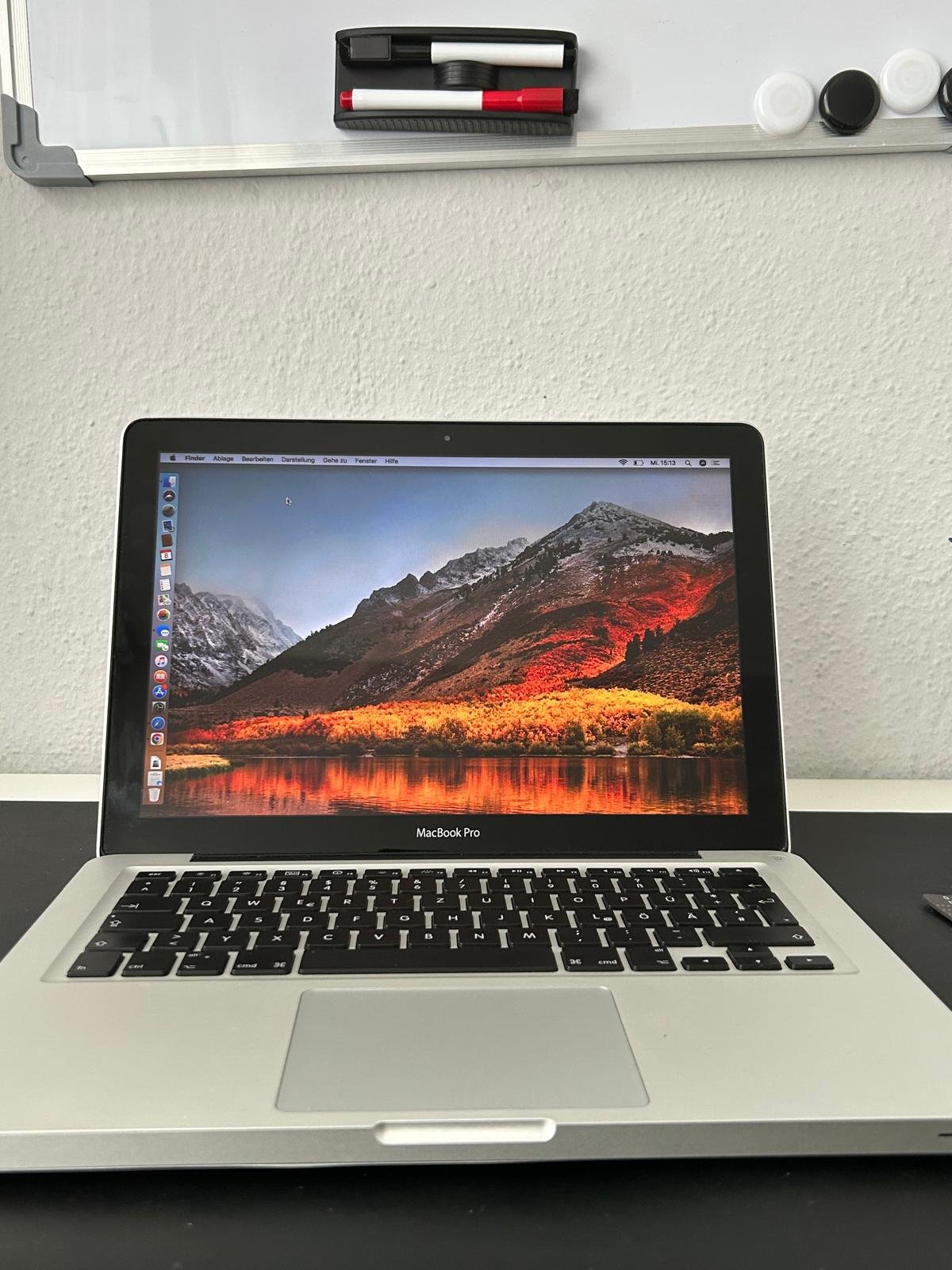 Geöffnetes MacBook Pro mit eingeschaltetem macOS-Bildschirm auf dem Schreibtisch