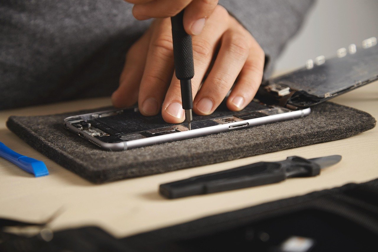 Symbolbild einer Smartphone-Reparatur mit Schraubendreher