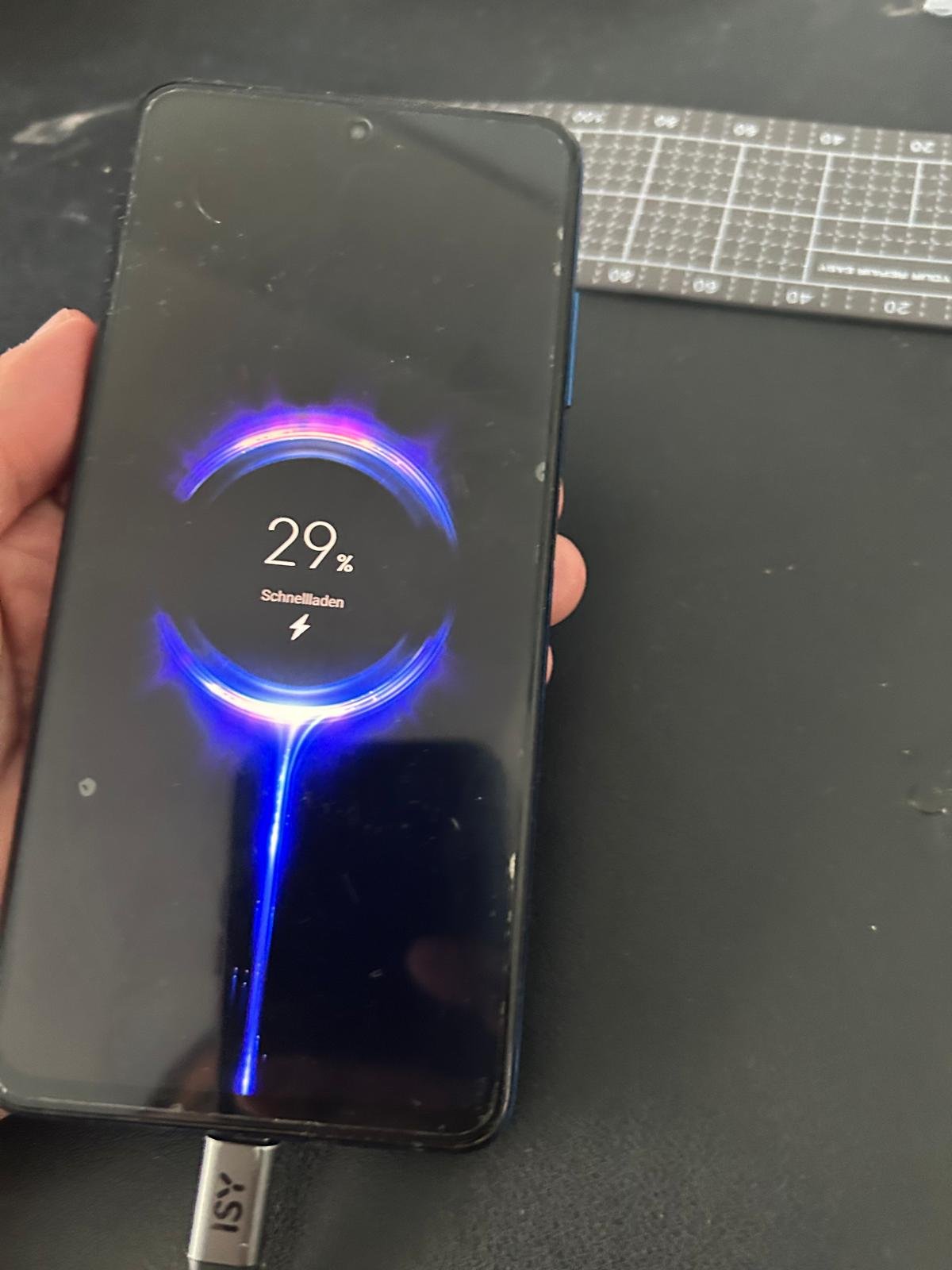 Smartphone am Ladekabel mit aktiver Schnellladeanzeige